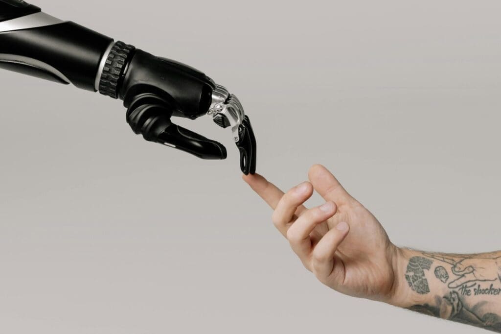 Robot hand touching tattooed human hand